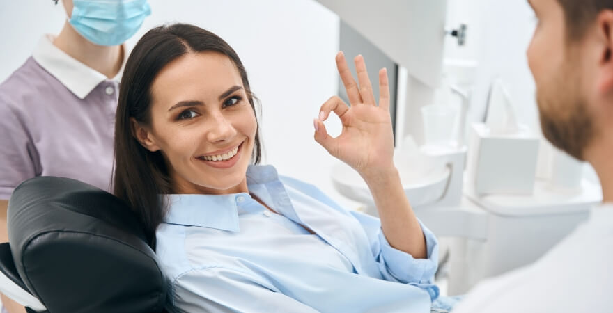 Dental patient making okay sign with her hand after cracked tooth treatment in Livingston