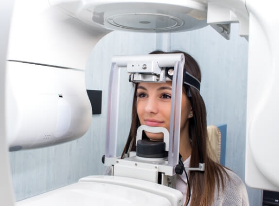 Woman getting a C T cone beam scan of her mouth and jaw in dental office